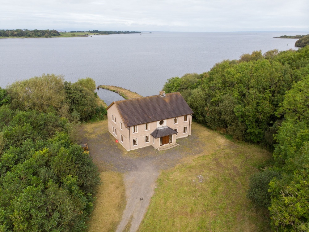 A birds-eye view of 34 Raughlan Lane's exterior. This property rests of the shores of Lough Neagh. This is a large, detached house with woodland surrounding the gardens. Image used in the Houses for sale in Armagh blog post.