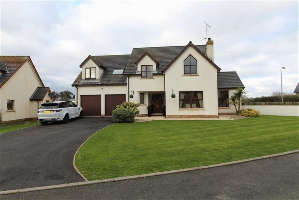 The exterior of Church Lane, a home for sale in Co. Down. This is a detached home with integral garage. Well maintained lawns are seen to the front of the property. A tarmac driveway is seen to the left of the property.