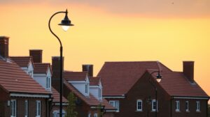 The rooftops of houses with an orange sky behind them. Image used in the Housing market in Northern Ireland is gaining strength blog post