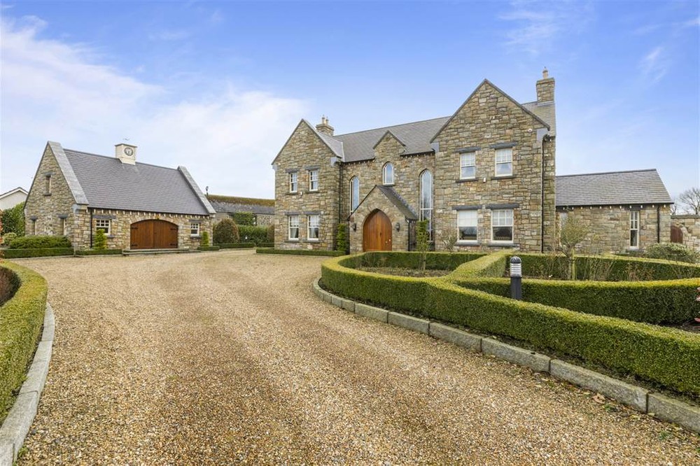 The exterior of 191 Battery Road, a large, detached family home for sale in Co. Tyrone. This is a stone fronted property with plenty of character. Neat hedges line the stone driveway which leads to the front of the house.